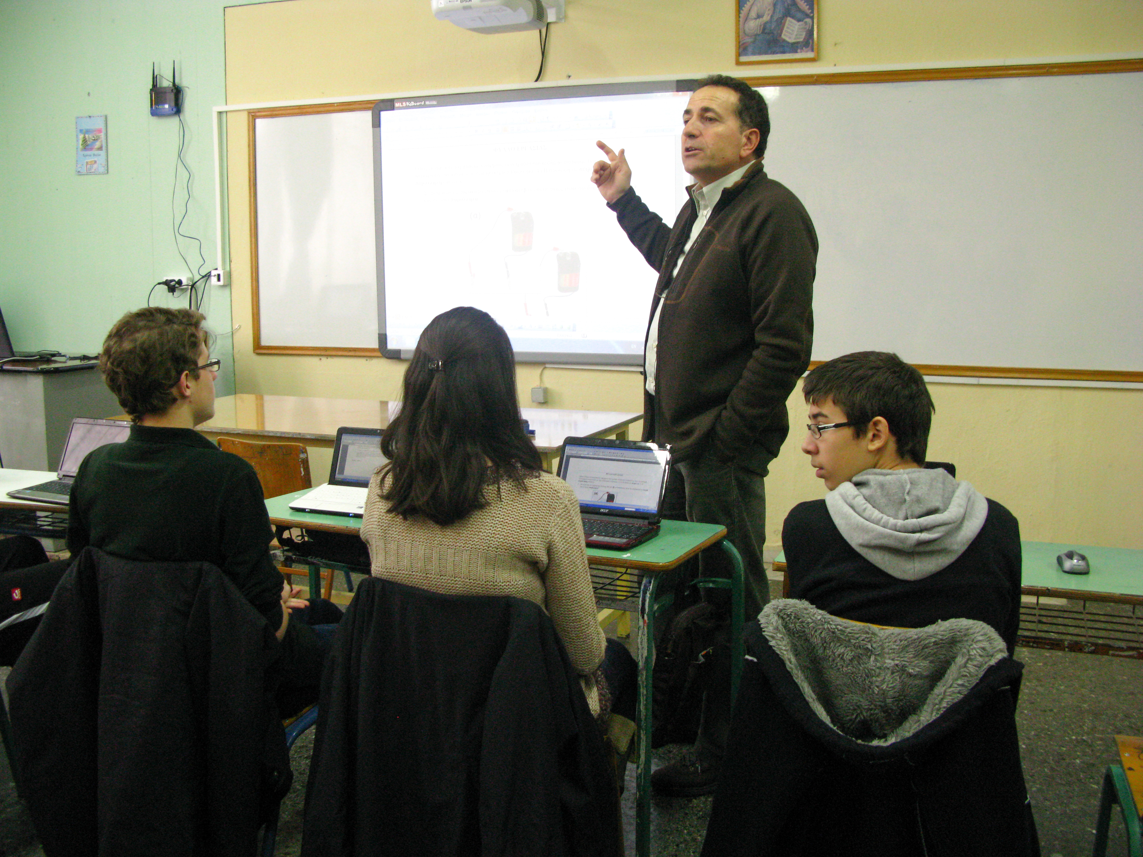 Lycée à Kozani – Quelques étudiants disposant d’un ordinateur portable personnel, en compagnie de leur professeur, Bob Apostolou.