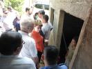 12 year old son of mother of three, Rosa Fernandez showing President Hoyer and Vice-President Alvarez his family’s current system of boiling water collected during the irregular two hour supply provided most nights